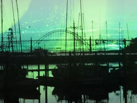Reflective Waters: Boat masts and an arched bridge silhouetted over green-lit water